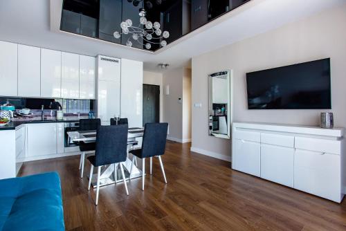 a kitchen and dining room with a table and chairs at Apartamenty Bristol in Kielce