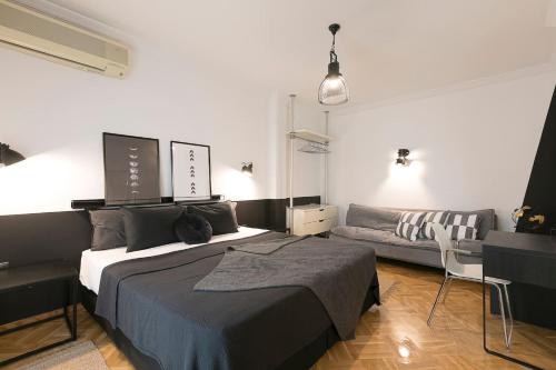 een slaapkamer met een bed en een bank bij #FLH - Traveller`s Nest in Thessaloniki