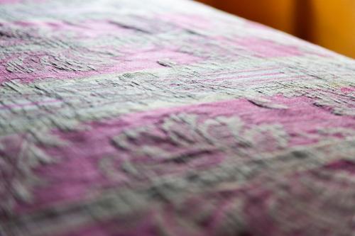 a close up of a bed with pink and purple sheets at La Rimbecca Greve in Chianti in Greve in Chianti