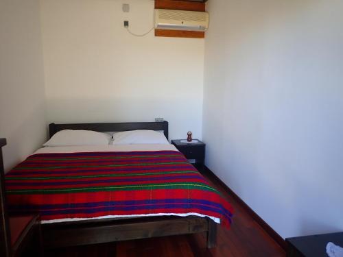 a bedroom with a bed with a colorful blanket on it at Holiday Home Jukići in Seline