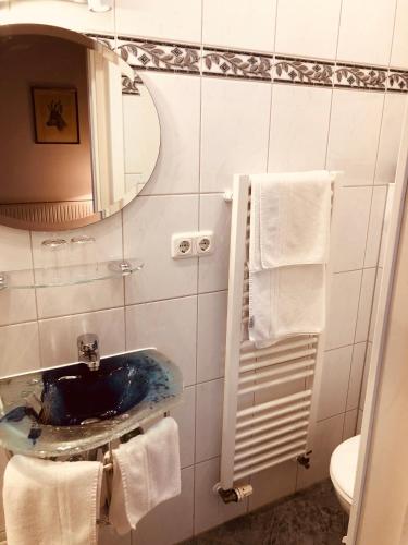 a bathroom with a sink and a mirror and towels at König Ludwig Stub´n in Prien am Chiemsee
