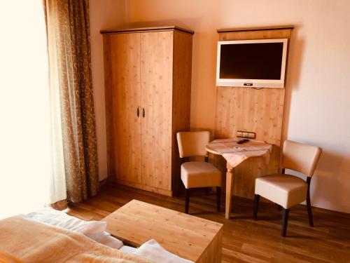 a room with a table and a tv and a bed at König Ludwig Stub´n in Prien am Chiemsee