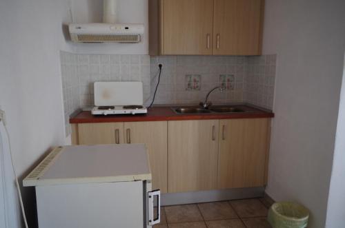 una pequeña cocina con fregadero y microondas en Esperos Hotel en Troulos