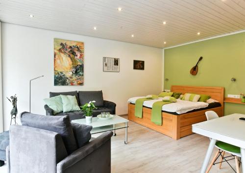 a living room with a couch and a bed at Appartements Moselblick in Klotten