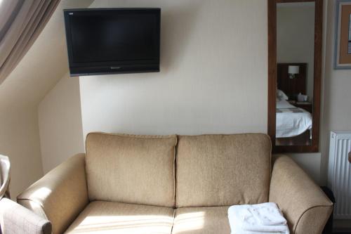 a living room with a couch and a flat screen tv at Mackays Hotel in Wick
