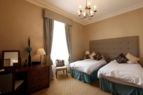 Un pat sau paturi într-o cameră la Mackays Hotel