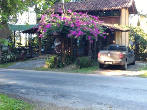 a car parked in front of a building with flowers at Chalés Vale dos Pássaros Refúgio nas montanhas in Paraty