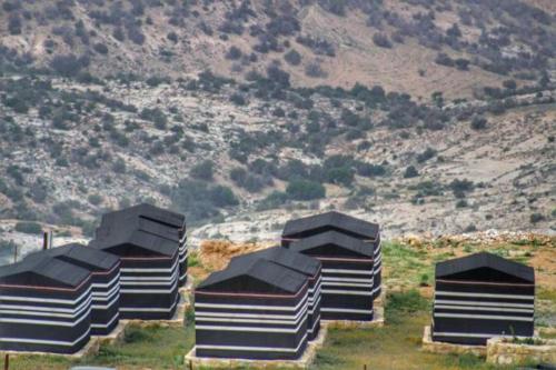 a group of structures sitting on top of a hill at Ein lahda camp-site in Dana