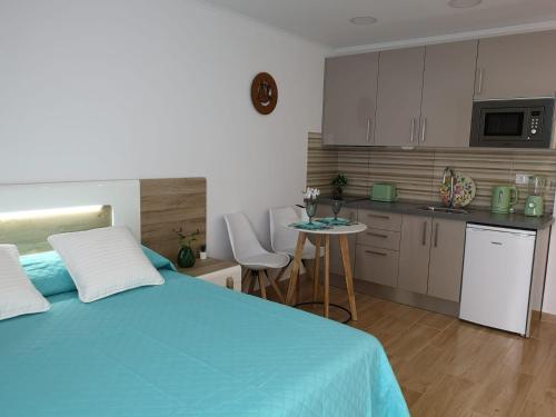 1 Schlafzimmer mit einem blauen Bett und einer Küche in der Unterkunft Lux Home in Albufeira