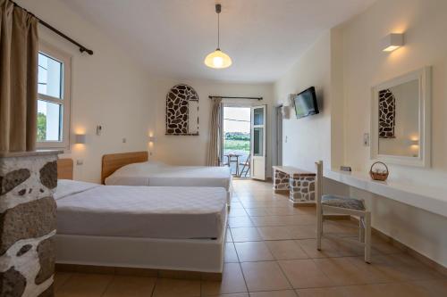 a hotel room with a large bed and a large window at Filoxenia Apartments in Adamas