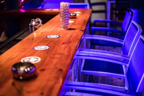 a long wooden table with blue chairs around it at The Ritz Hostel in Willemstad
