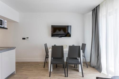 a dining room with a table and chairs and a tv at 2NIGHTSTUDIOS in Split