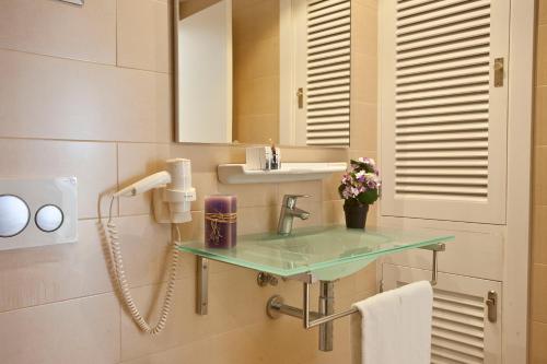 a bathroom with a sink and a mirror at Apartamentos Ferrera Pins in Cala Ferrera
