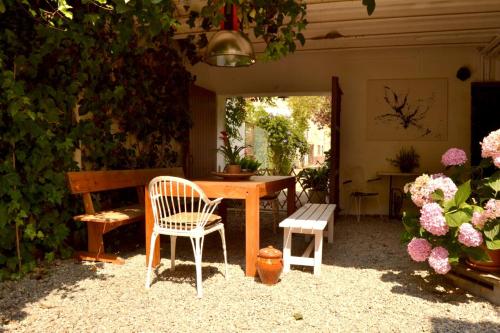 a wooden table and chairs in a yard with flowers at Marakasa B&B in Sant Antoni de Calonge