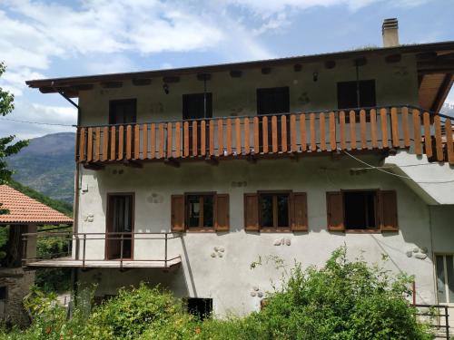 uma casa antiga com uma varanda em cima em Casa per vacanze in Meana di Susa em Meana di Susa