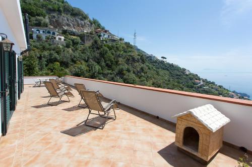 a balcony with chairs and a fireplace on a mountain at "CASALENA" Villa a Furore Amalfi coast con grande terrazzo e vista sul MARE in Furore