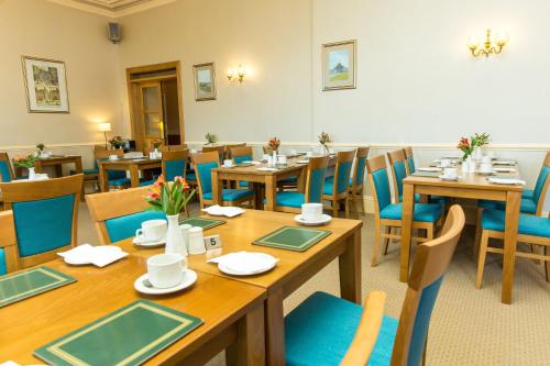 a dining room filled with tables and chairs at Mackays Hotel in Wick
