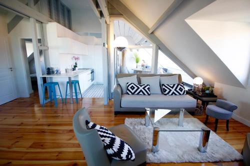 een woonkamer met een bank en een tafel bij Loft en duplex avec terrasse Halles in Biarritz