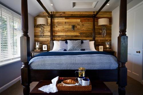 um quarto com uma cama e uma parede de madeira em Hazelhurst Farm em Sway