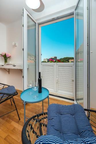 a living room with a blue table and a large window at Apartments Simović in Dubrovnik