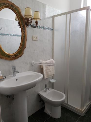 a white bathroom with a sink and a shower at Locanda Elena in Equi Terme