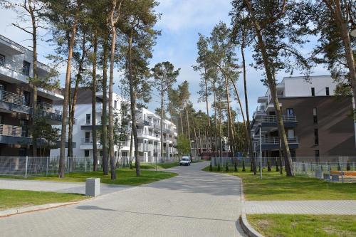 eine Straße mit Bäumen und ein Auto, das eine Straße entlangfährt in der Unterkunft Apartament RELAX in Pogorzelica