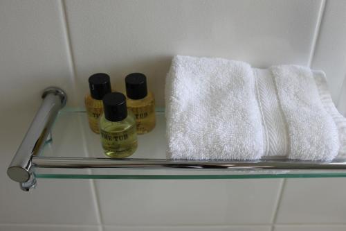 a shelf with two bottles of soap and a towel at Mackays Hotel in Wick