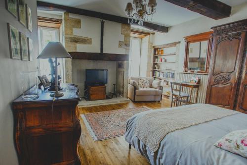 ein Schlafzimmer mit einem Bett und ein Wohnzimmer in der Unterkunft Chambre d'hôtes Au jardin de la Bachellerie in La Bachellerie