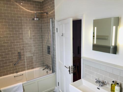 a bathroom with a tub and a sink and a mirror at Harbourmaster Hotel in Aberaeron