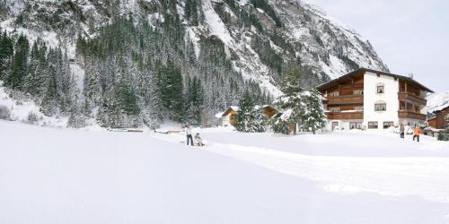 a ski lodge in front of a snow covered mountain at Gletscher-Landhaus Brunnenkogel in Sankt Leonhard im Pitztal