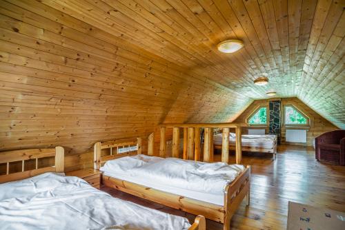 a bedroom with two beds in a wooden cabin at Zrubové chaty Stará Lesná in Stará Lesná