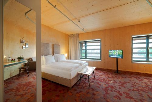 a bedroom with a bed and a tv in a room at Raphael Hotel Wälderhaus in Hamburg