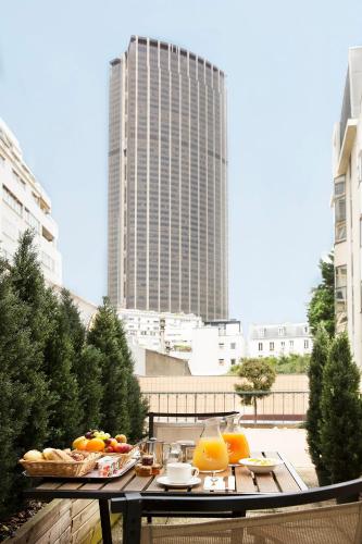 a table with a tray of fruit on a balcony at Hôtel Le M in Paris