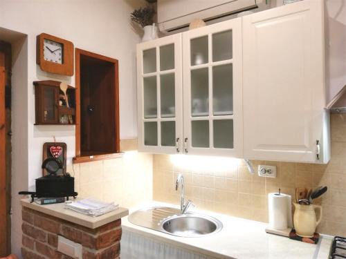 una cocina con armarios blancos y fregadero en Guesthouse Trogir Proto, en Trogir