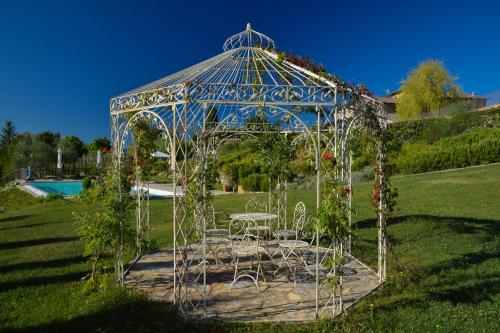 a gazebo with a table and chairs in a field at Cavarchino B&B in Gaiole in Chianti