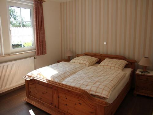 Un dormitorio con una cama grande y una ventana en Ferienwohnung Die Fuchsmühle, en Niedermeiser