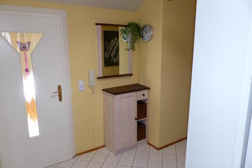 a room with a small cabinet and a clock on the wall at Apartment mit Ausblick in Wörth am Rhein