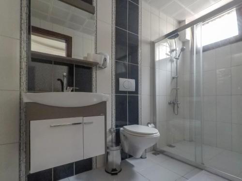 a bathroom with a toilet, sink, and shower at Eyna Hotel in Fethiye