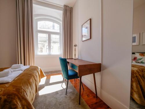 a bedroom with a desk and a bed and a window at Fanqueiros 196 - Center City Apt in Lisbon