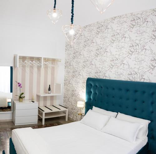 Schlafzimmer mit einem Bett mit blauem Kopfteil in der Unterkunft Liberty house in Syrakus