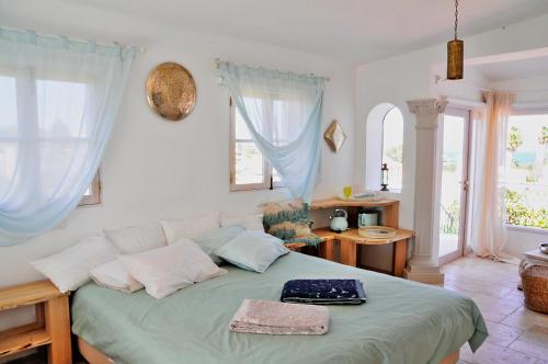 a bedroom with a bed with a green comforter at Uma Casa a Beira Sol in Lagos