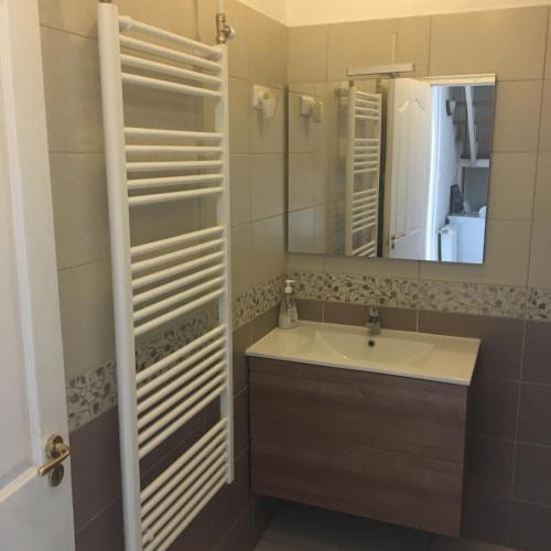 a bathroom with a sink and a mirror at Beta Apartman in Bük