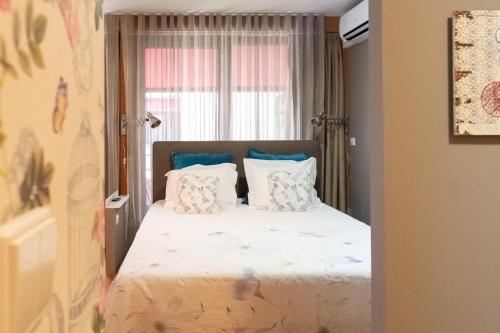 a bedroom with a bed with pillows and a window at Casas do Teatro in Porto