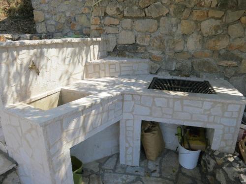 a stone fireplace in front of a stone wall at Reževići Apartments in Petrovac na Moru