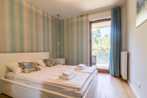 - une chambre avec un lit et une grande fenêtre dans l'établissement Nadmorski, à Gdańsk