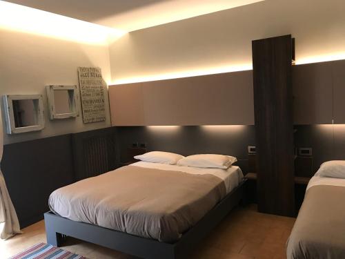 a bedroom with two beds and lights on the wall at Casa Bona in Alba