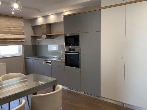 a kitchen with white cabinets and a table with chairs at Boutique Hotel Center in Kecskemét