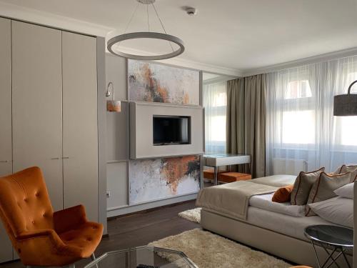 a living room with a couch and a tv at Boutique Hotel Center in Kecskemét
