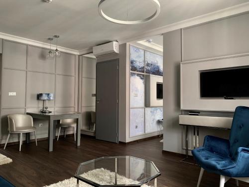 a living room with a tv and a couch and a table at Boutique Hotel Center in Kecskemét