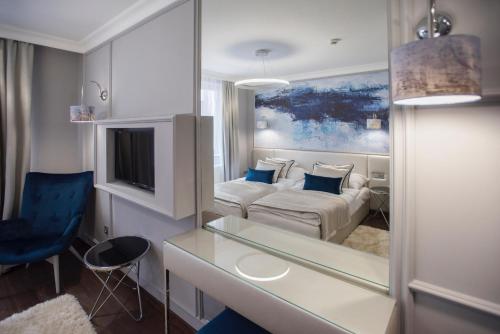 a living room with a white couch and a mirror at Boutique Hotel Center in Kecskemét